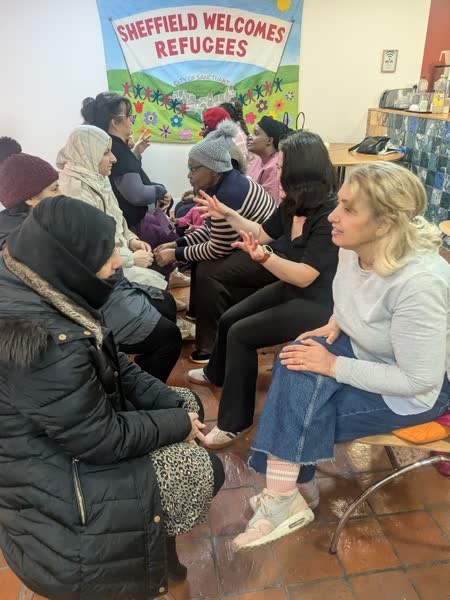 A seated community gathering at Sheffield Welcomes Refugees